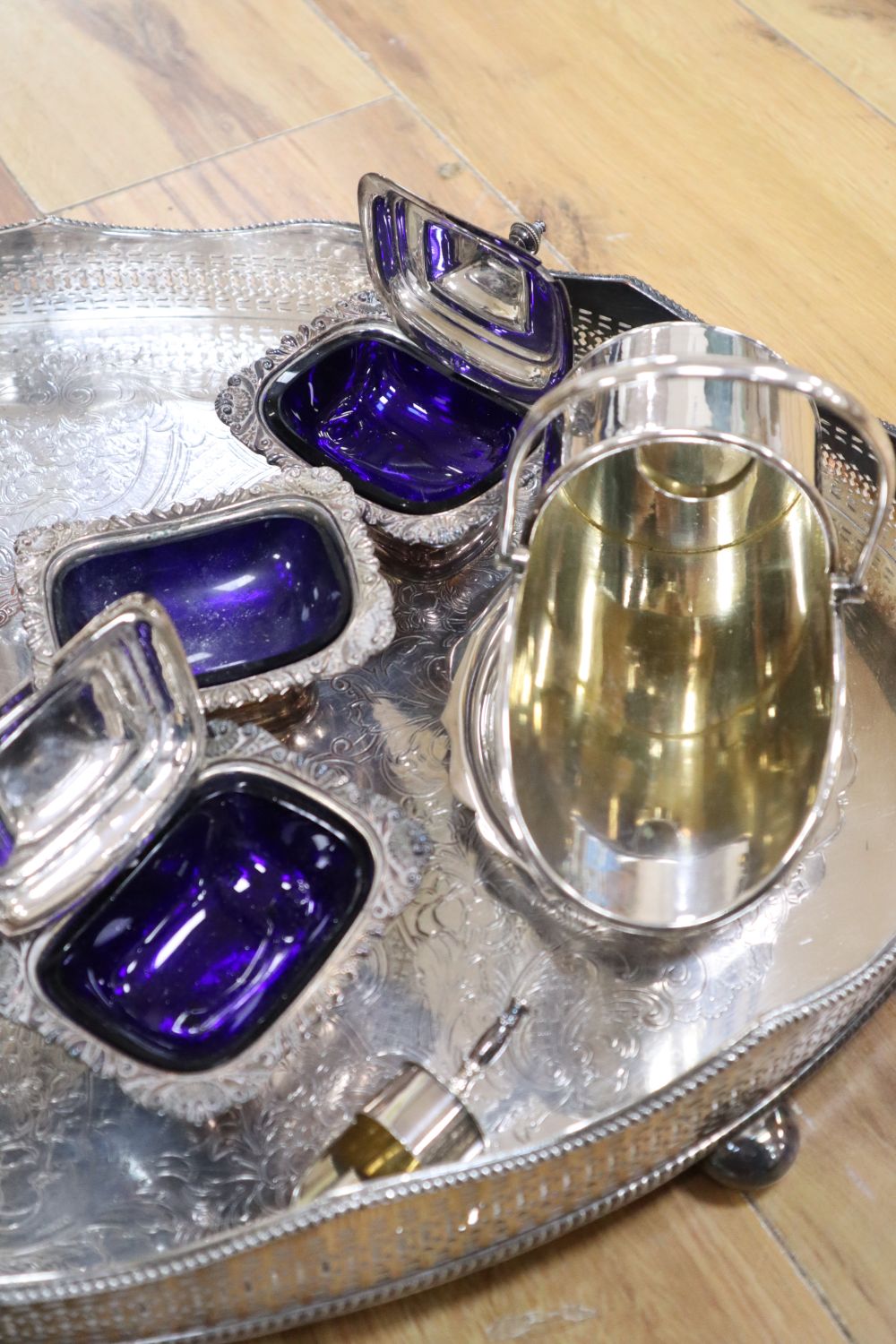 A large oval plated galleried tray and a collection of plated items,